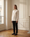 Chemise femme coupe droite, coloris écru, portée dans un intérieur haussmannien parisien
