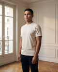 T-shirt col rond homme, coloris écru, porté dans un intérieur haussmannien parisien