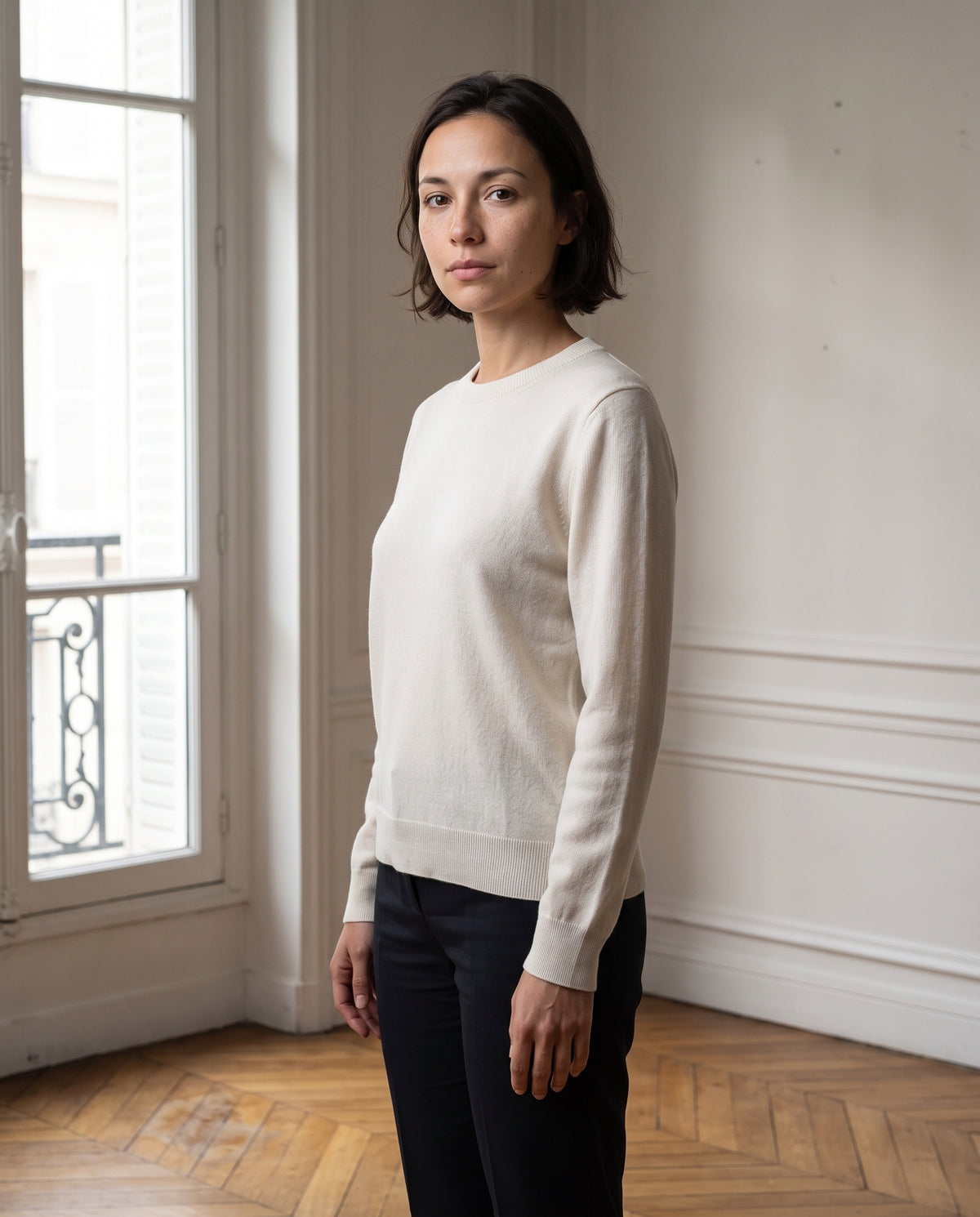 Pull femme col rond, coloris écru, porté dans un intérieur haussmannien parisien