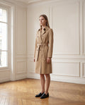 Trench femme mi-long à ceinture, coloris camel, porté dans un intérieur haussmannien parisien